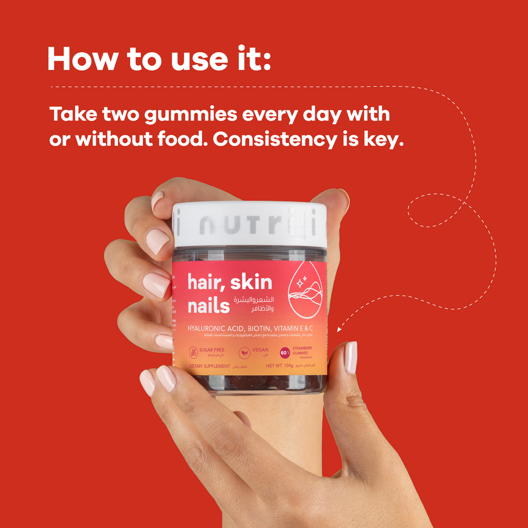 Hand holding a supplement container with text on how to use it against a red background